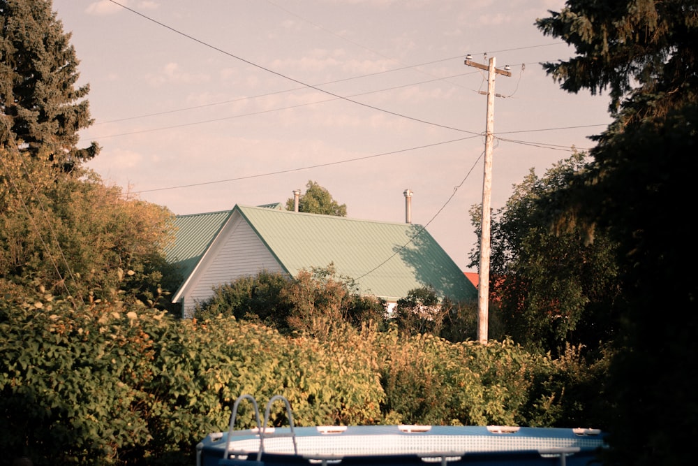 white car parked beside green house