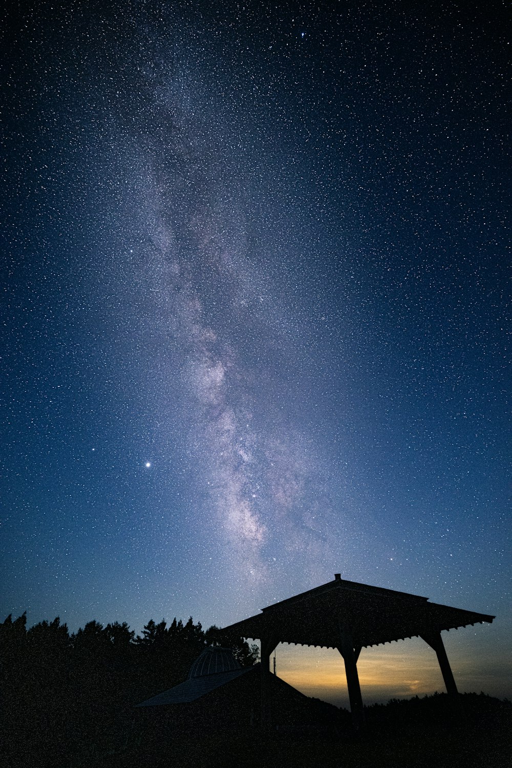 silhouette of house under starry night