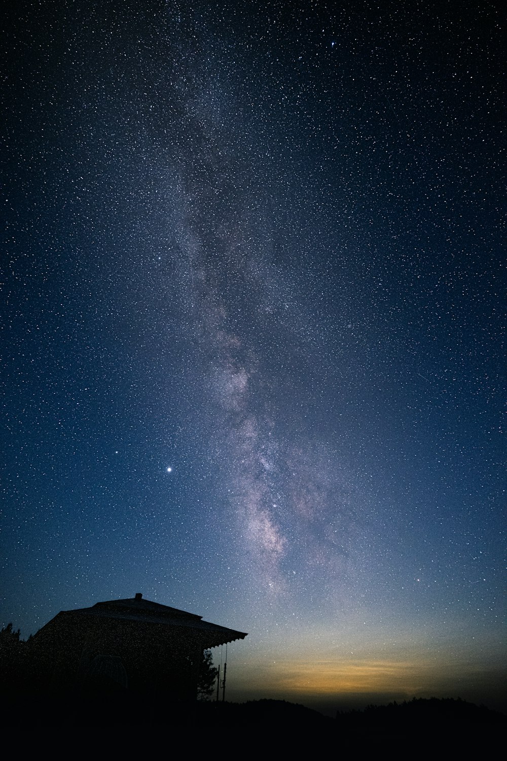 silhouette of house under starry night