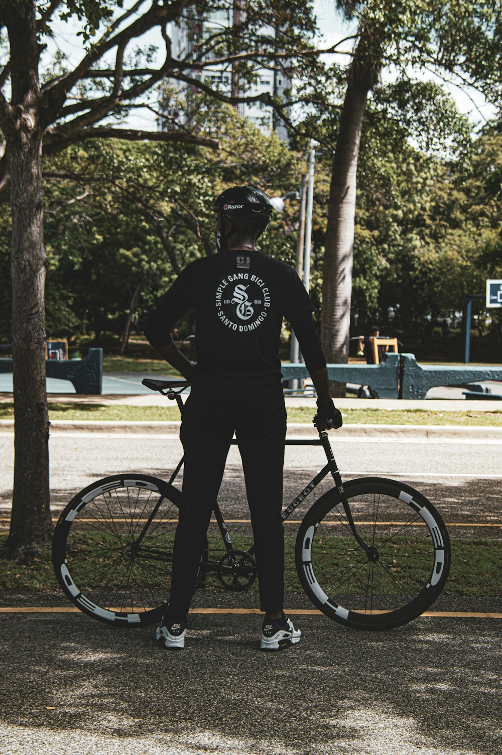 man in black t-shirt and black pants riding bicycle during daytime