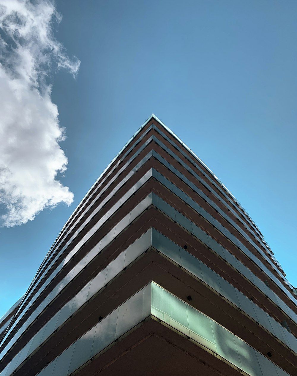 Edificio de hormigón blanco y marrón bajo el cielo azul durante el día