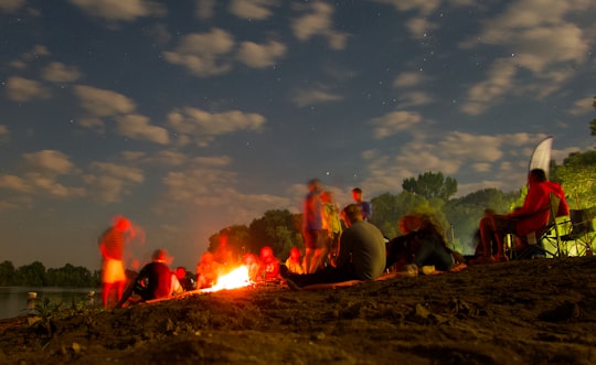 people sitting on ground near bonfire during night time in Ibrány Hungary