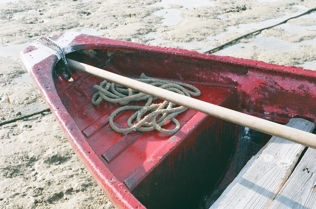 brown and red boat on brown sand during daytime