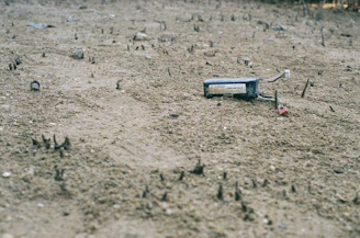 Wide shot of a treasure hunter scanning rocky terrain with advanced underground imaging gear