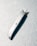 A metallic utility knife lies diagonally on a textured surface. The knife has a retractable blade that is partially extended, casting a distinct shadow on the surface.