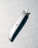 A metallic utility knife lies diagonally on a textured surface. The knife has a retractable blade that is partially extended, casting a distinct shadow on the surface.