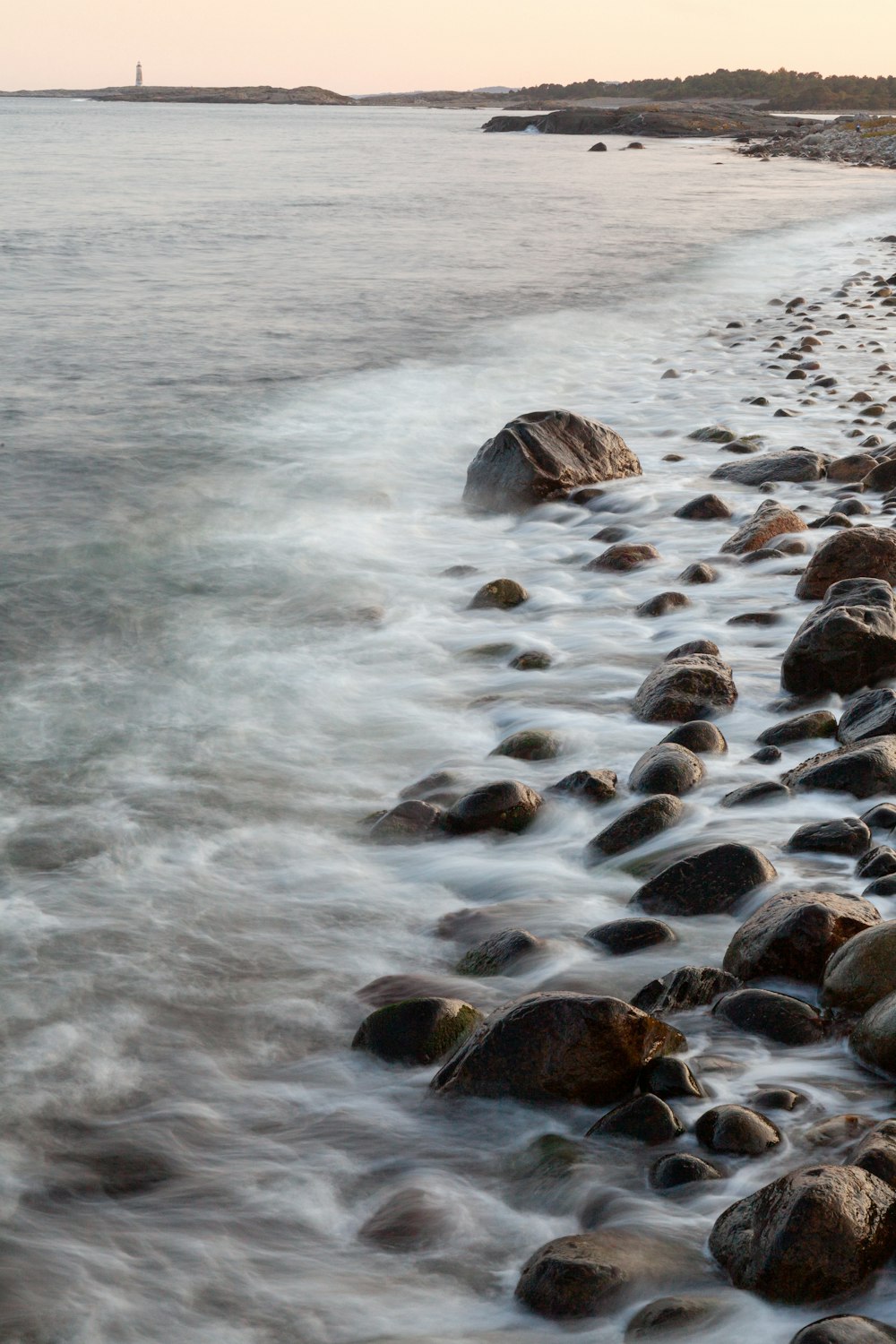 pierres noires et brunes sur le bord de la mer pendant la journée