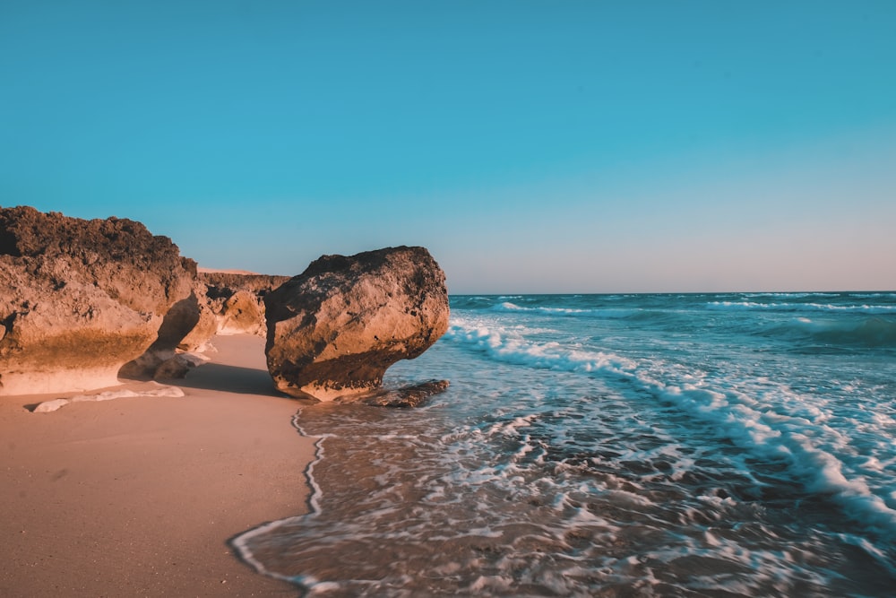 brown rock formation on sea shore during daytime