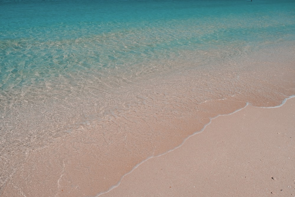 brown sand near body of water during daytime