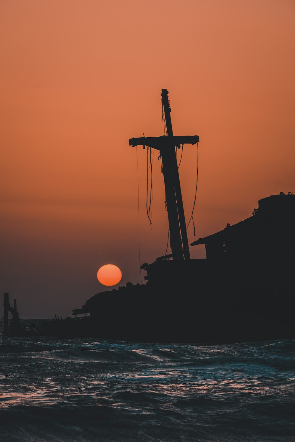 silhouette of ship on sea during sunset