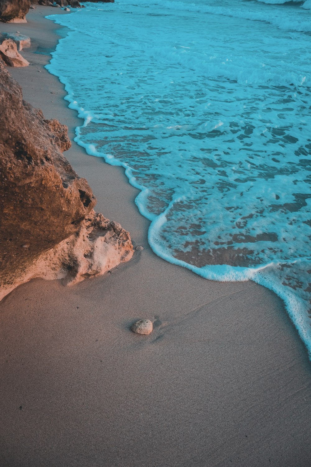 Playa de arena marrón con rocas marrones