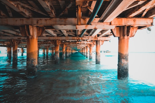 brown wooden dock over blue water in Kish Iran