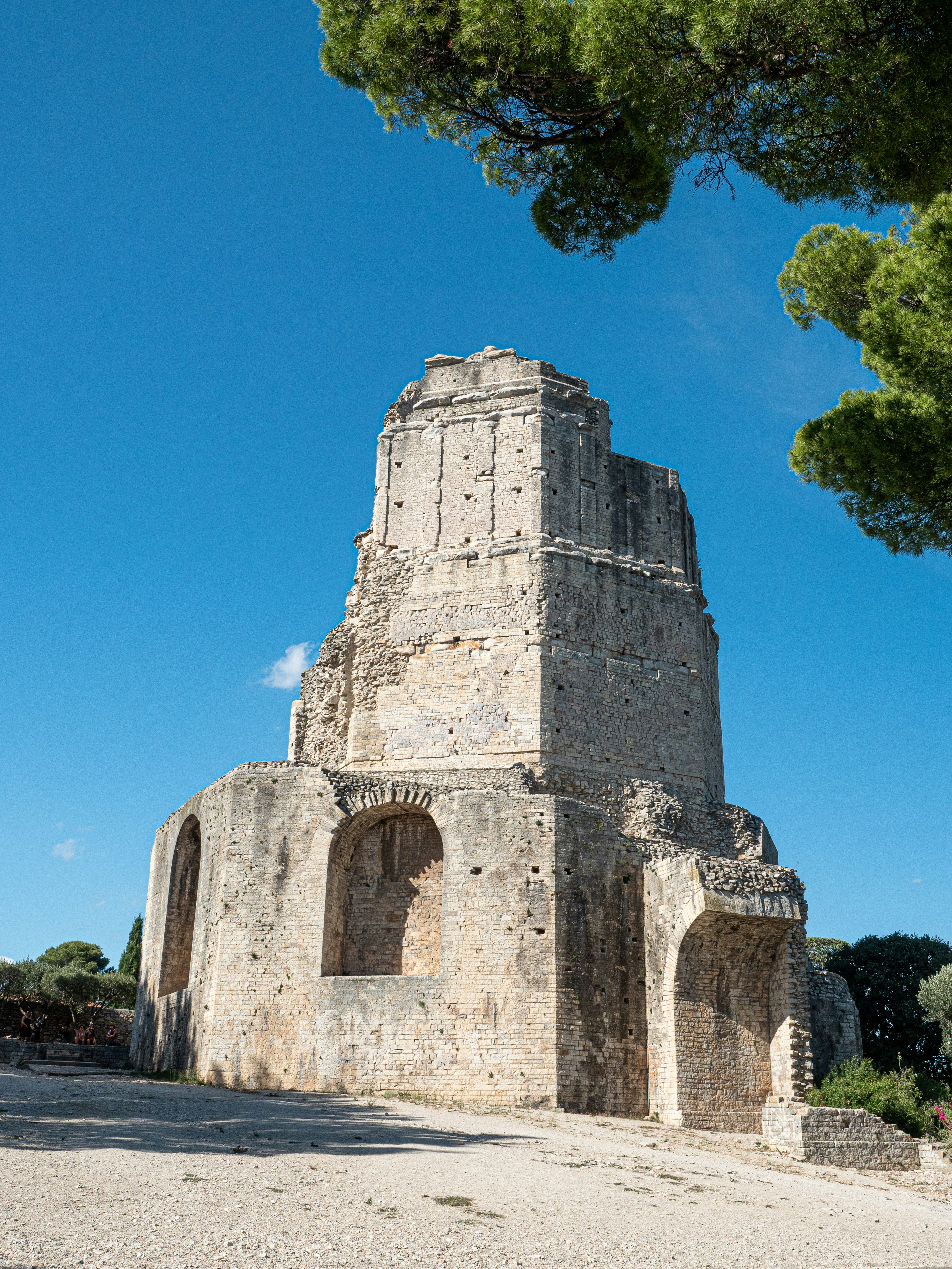 Edificio de hormigón gris cerca de árboles verdes bajo el cielo azul durante el día