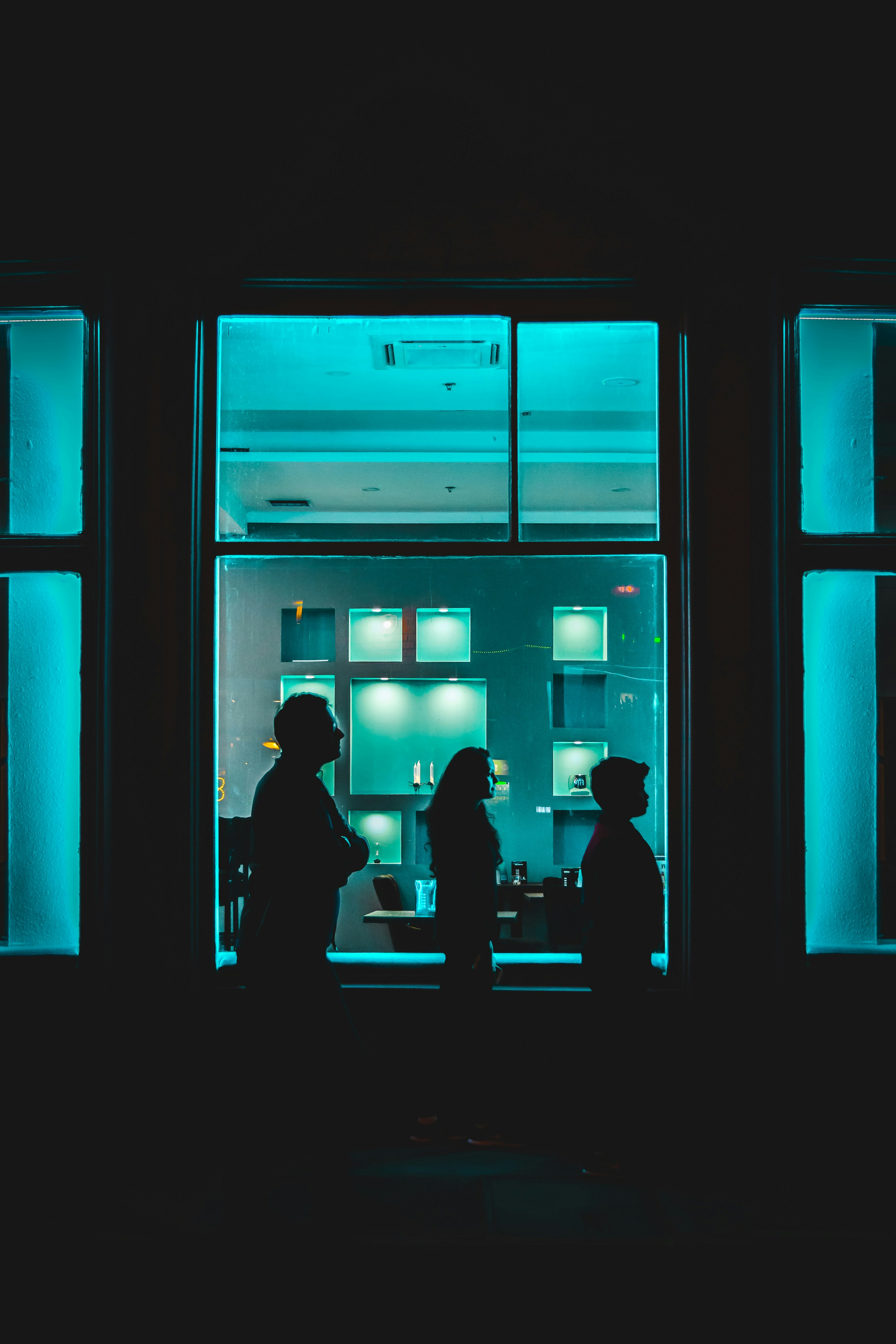 Un grupo de personas de pie frente a una ventana