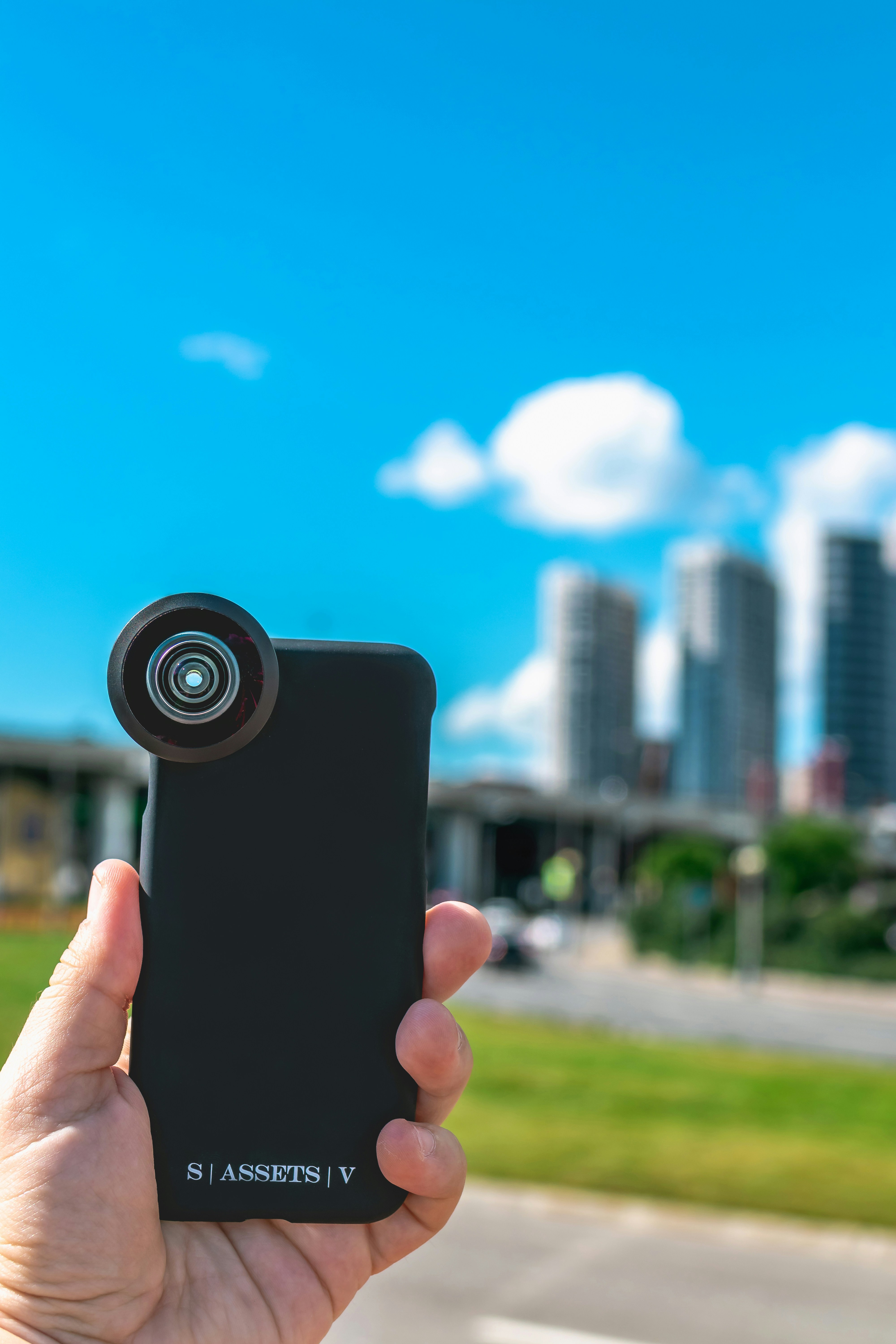 person holding black smartphone taking photo of city buildings during daytime