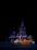A brightly illuminated building at night with an orange and black Uber taxi in the foreground. The building features elaborate architectural details and is lit with blue and orange lighting, creating a striking contrast against the dark sky.
