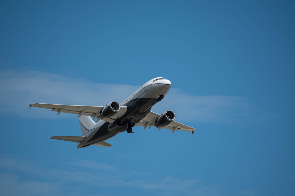 white airplane in mid air during daytime