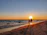 A romantic couple walking hand in hand along a sunset beach in Tulum.