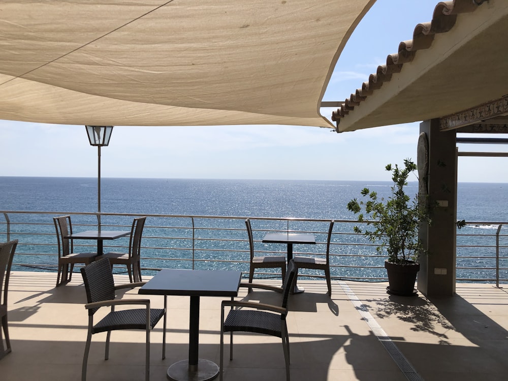 Table et chaises en bois brun près de la mer pendant la journée