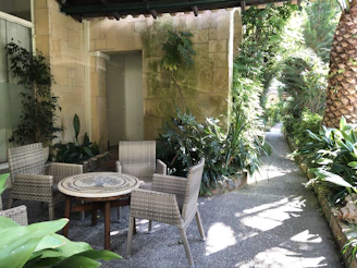 Private garden with Mediterranean plants and a cozy seating area.