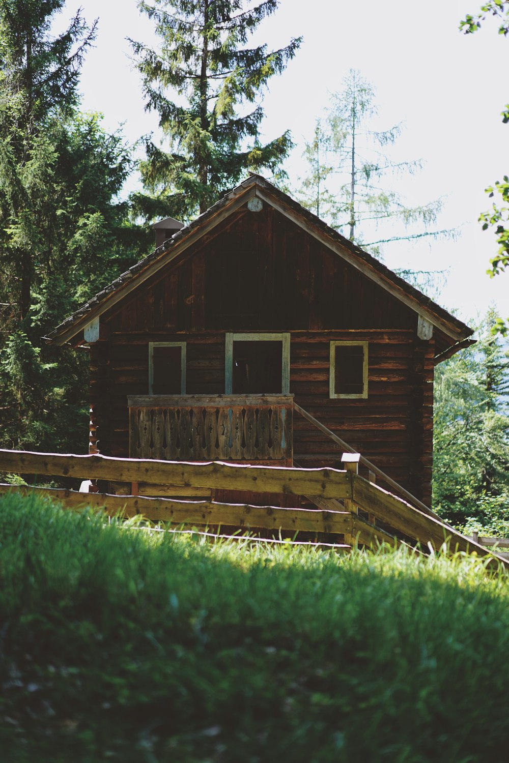casa de madeira marrom no campo verde da grama