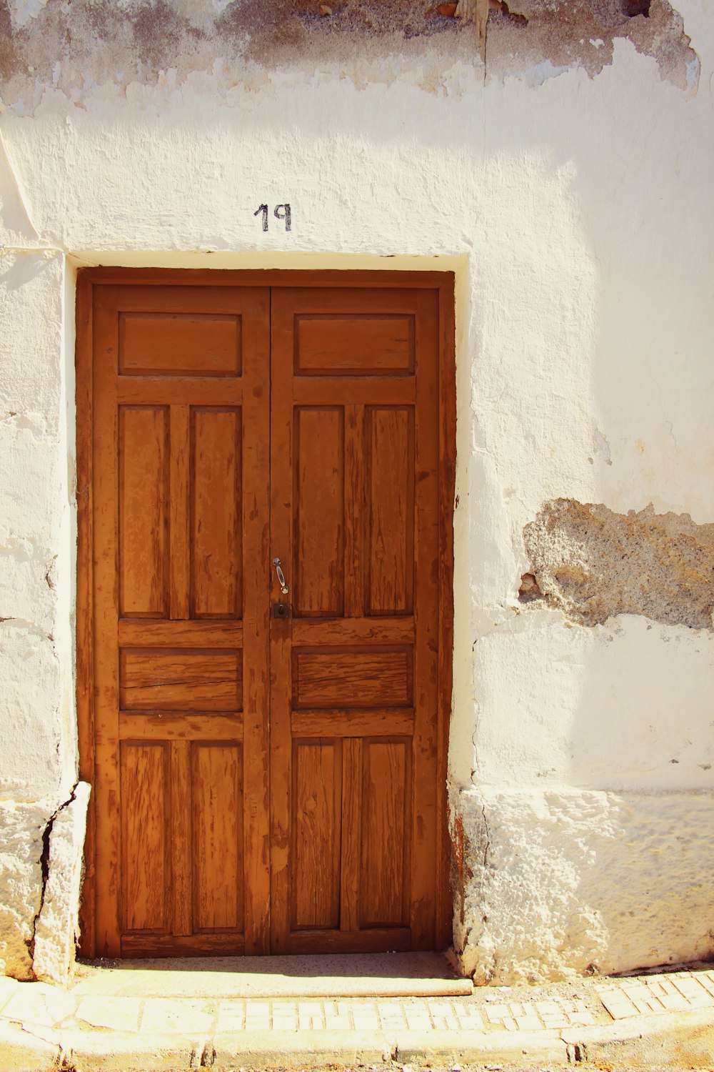 brown wooden door on white concrete wall