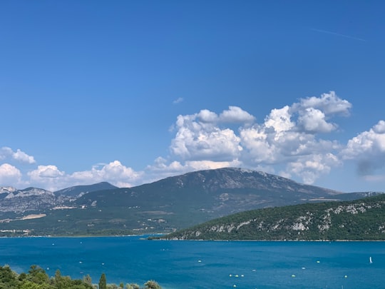 green mountains near body of water under blue sky during daytime in Alpes-de-Haute-Provence France