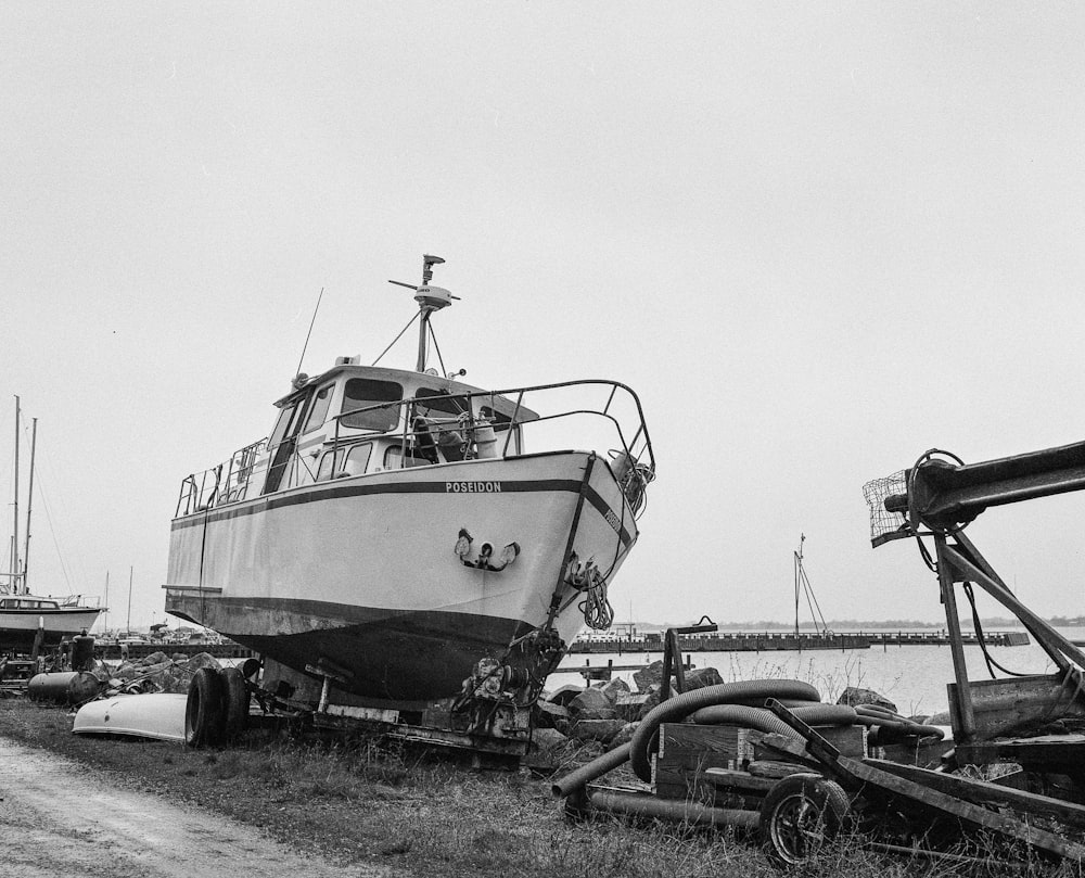 grayscale photo of a boat on a beach