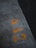 Concrete surface with weathered yellow numbers painted on it, shown in an industrial environment with a dark body of water to the side.