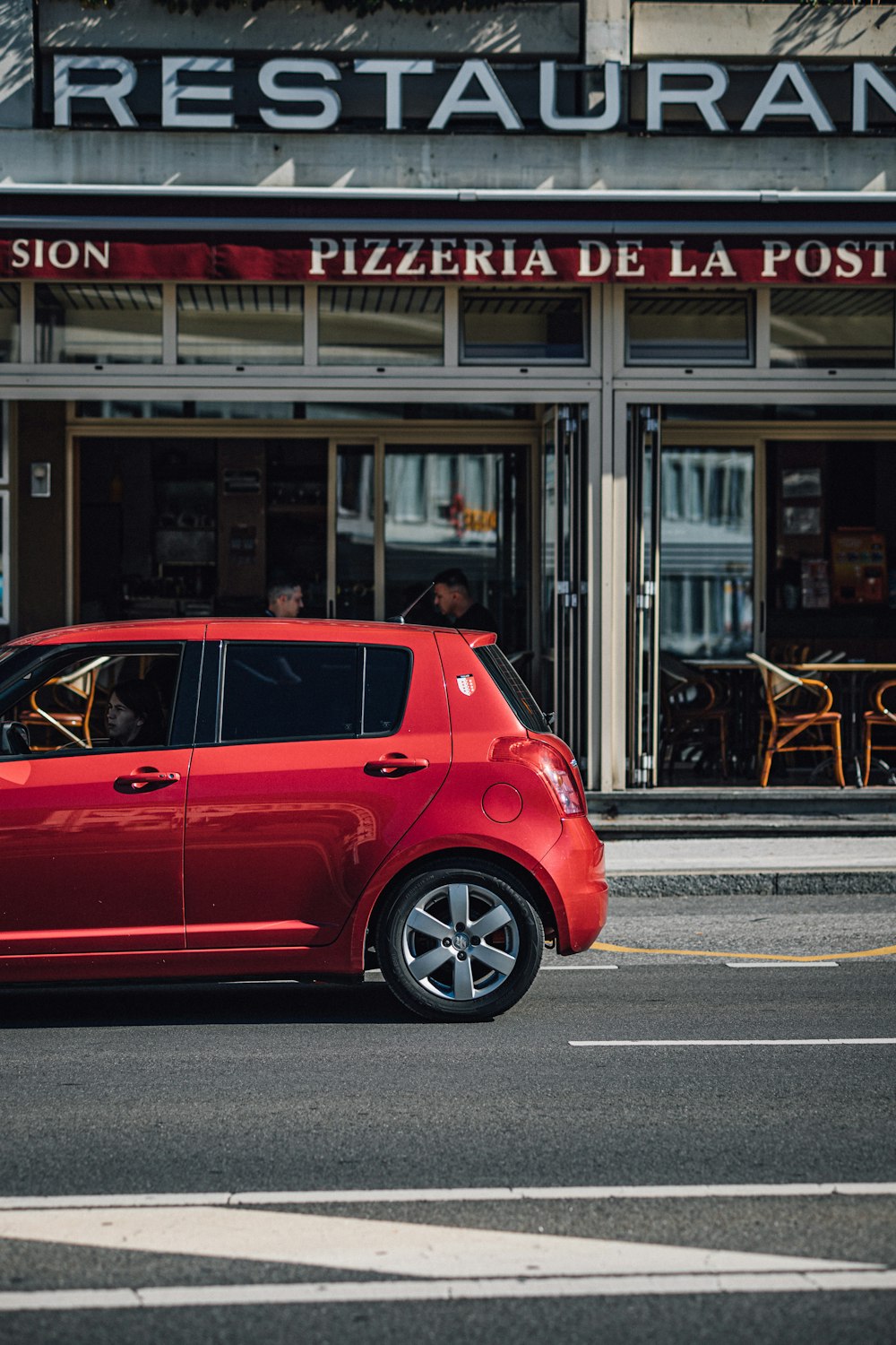 red 5 door hatchback on road during daytime