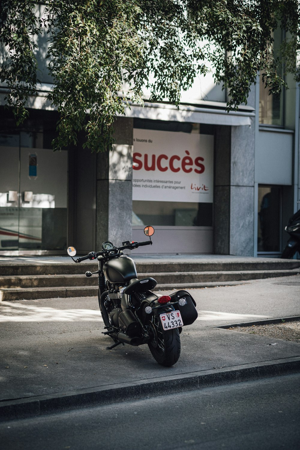 motocicleta preta e vermelha estacionada ao lado da estrada