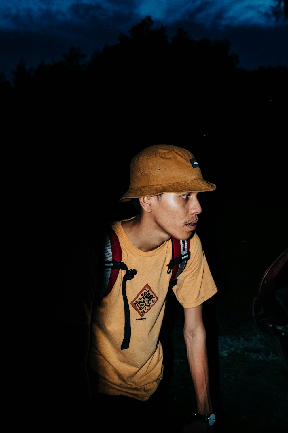 man in brown and black tank top wearing brown cap