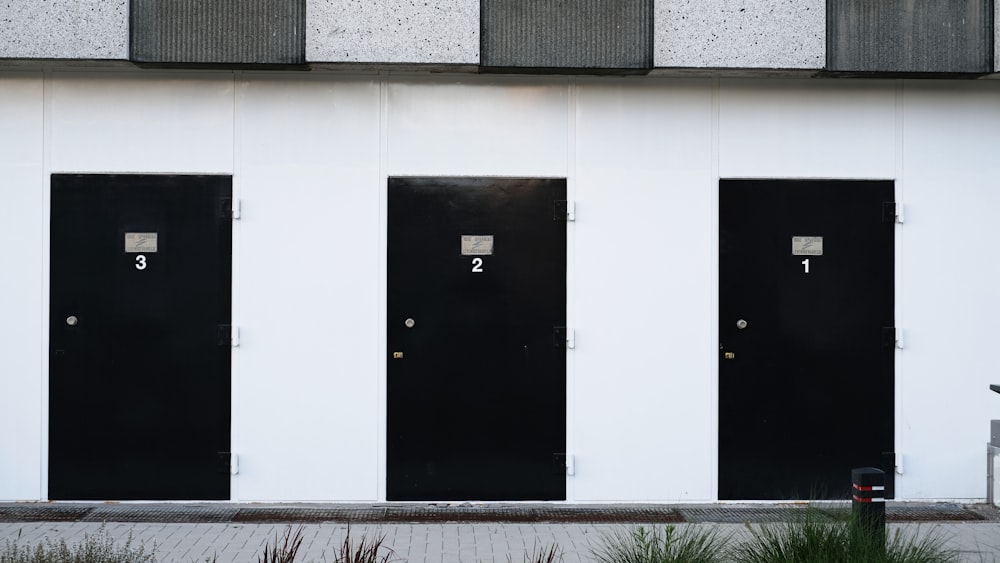 black door on white concrete wall