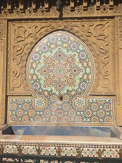 Close-up of a handcrafted cement fountain with intricate floral patterns in natural earthy tones
