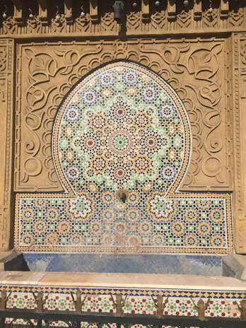 Close-up of a handcrafted cement fountain with intricate floral patterns in natural earthy tones