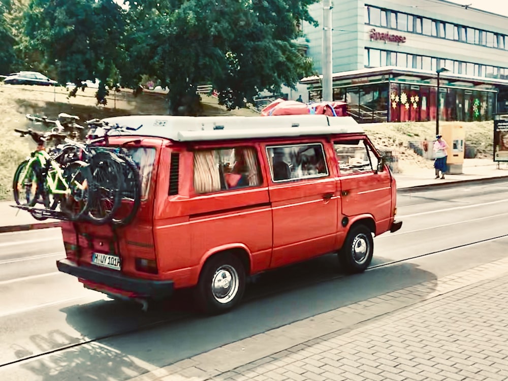 red and white volkswagen t-2 parked on sidewalk during daytime