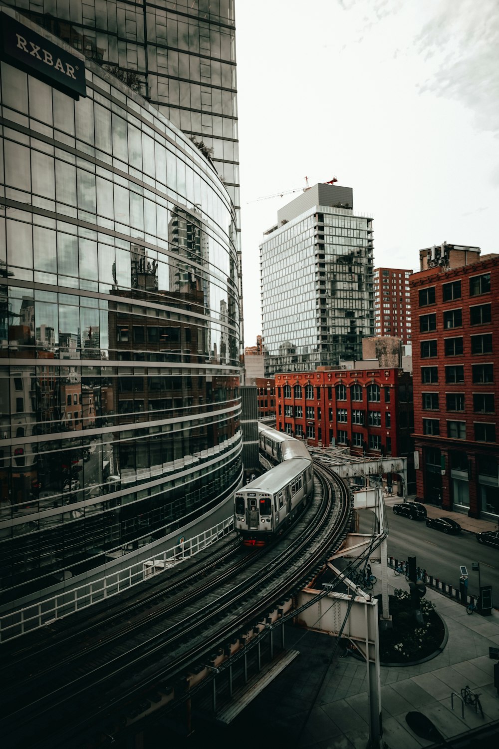 um trem viajando por uma cidade ao lado de edifícios altos