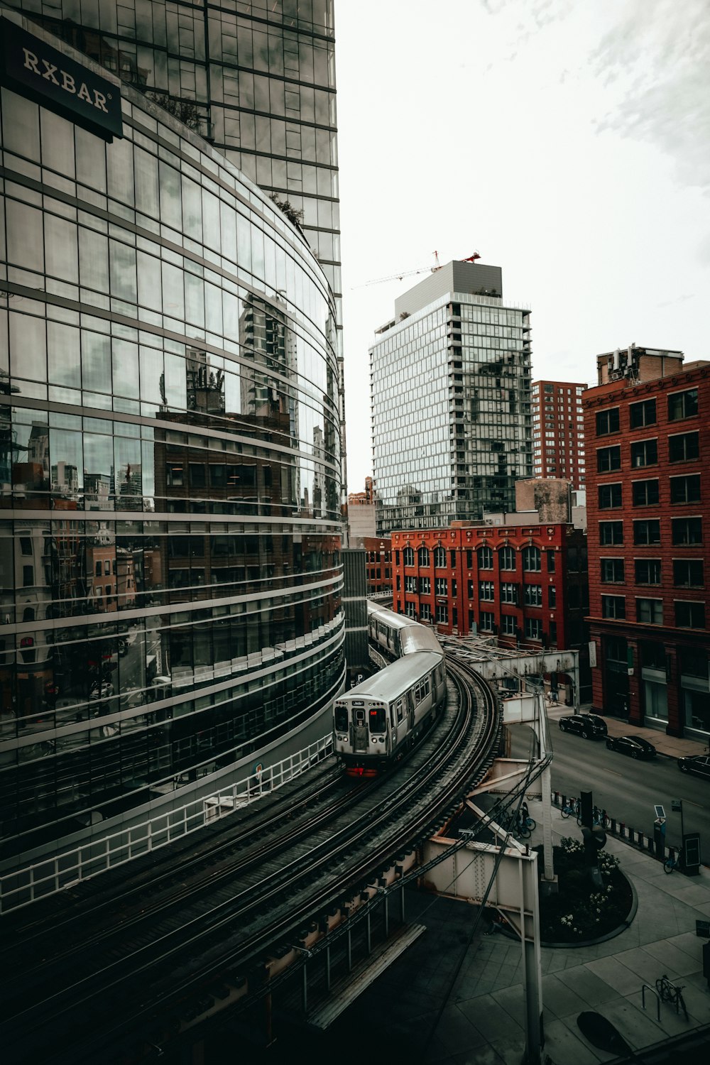 a train traveling through a city next to tall buildings