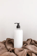 white plastic bottle on white table