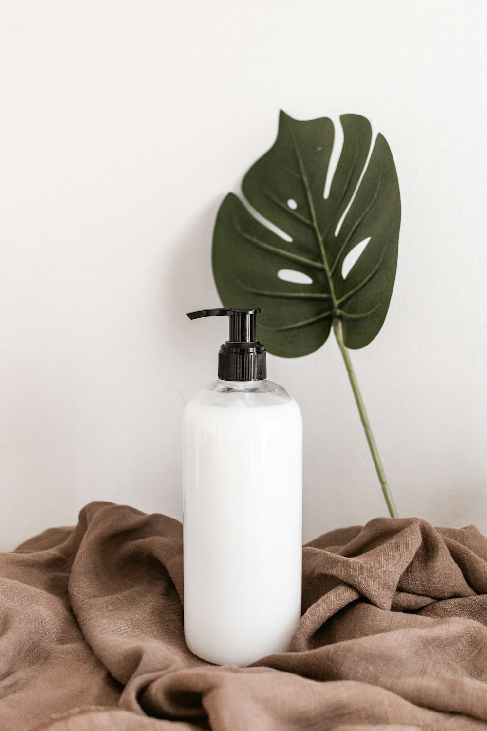 white plastic bottle on brown textile