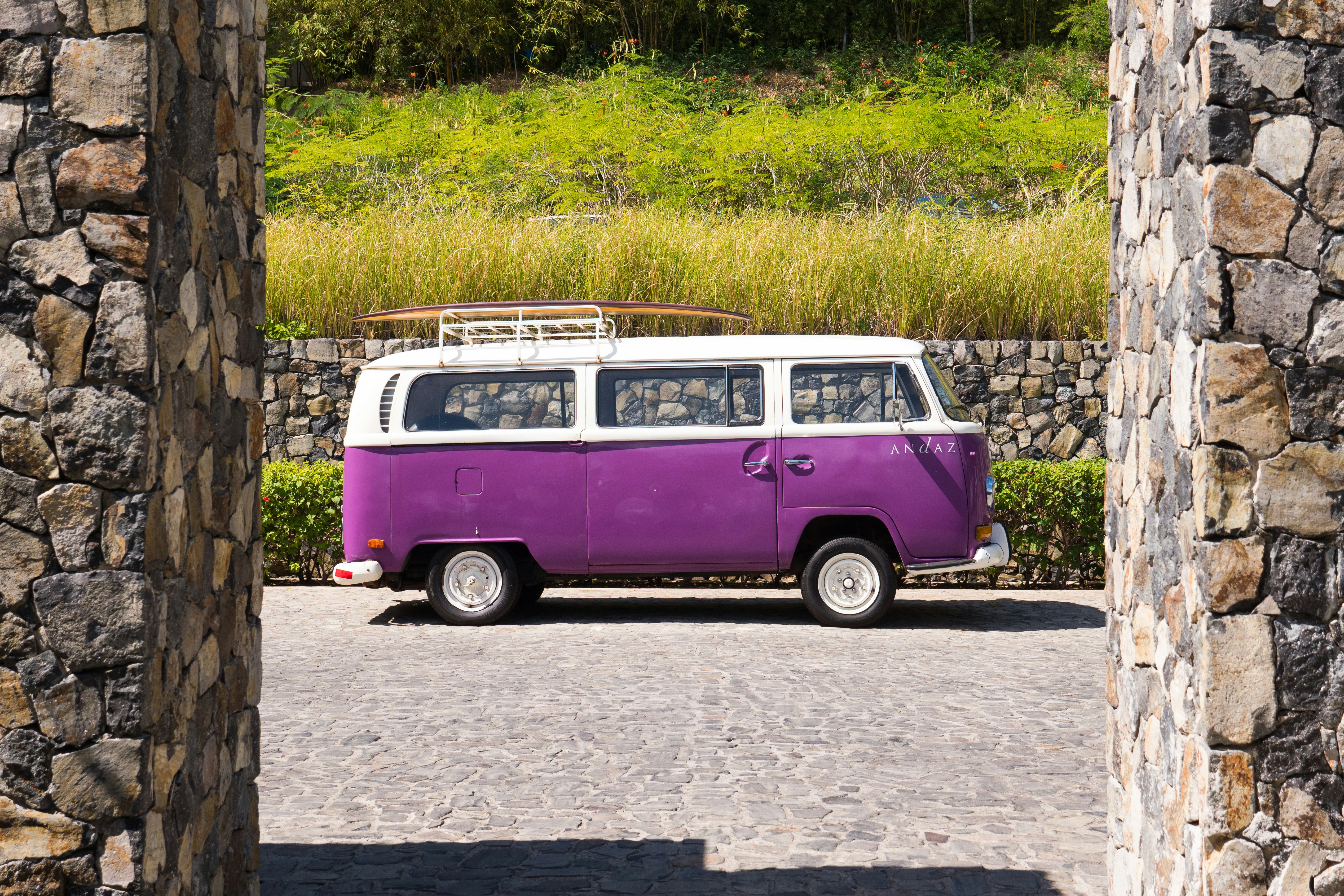 Volkswagen T-2 violet et blanc sur une route en béton gris pendant la journée