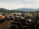 A panoramic view of Valle de Bravo's mountains with off-road vehicles parked nearby.