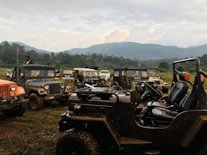 A panoramic view of Valle de Bravo's mountains with off-road vehicles parked nearby.