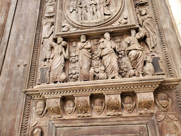 Detail of a wooden mural showing delicate hand-carved textures and shadows.