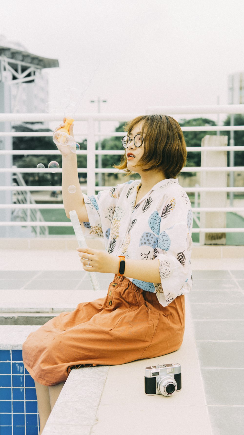 woman in white and blue floral long sleeve shirt and orange skirt