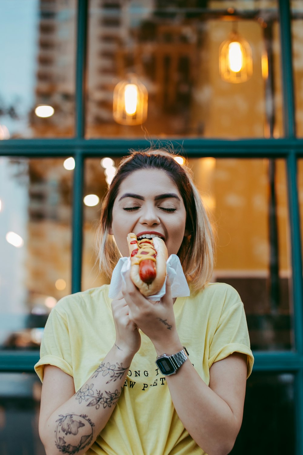 Mujer con camiseta blanca de cuello redondo comiendo manzana