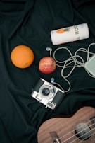 silver and black camera beside orange fruit