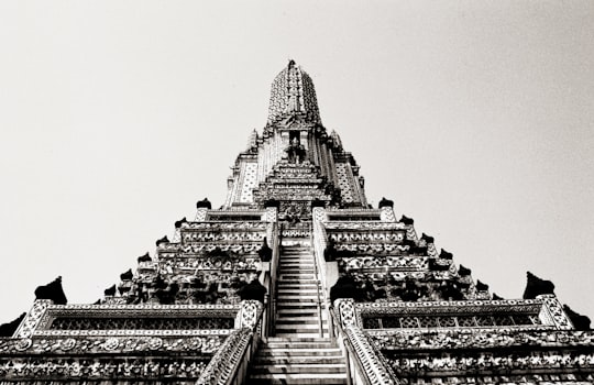 grayscale photo of concrete building in Wat Arun Ratchawararam Ratchawaramahawihan Thailand
