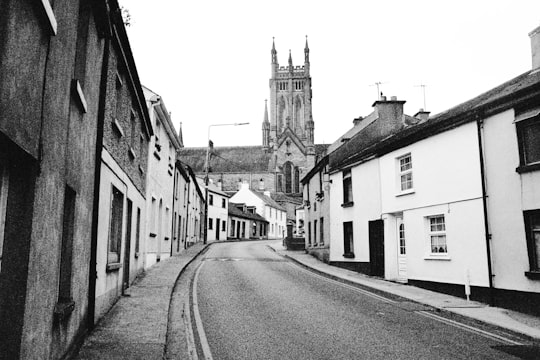 grayscale photo of a street in between buildings in Kilkenny Ireland