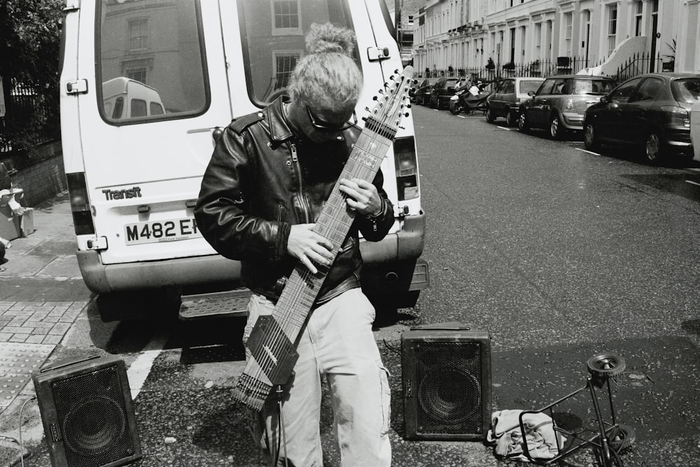 man in black jacket playing electric guitar